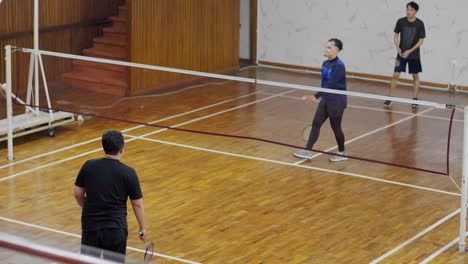 Group-Of-Asian-Men-Training-On-Indoor-Court-With-Rackets-And-Shuttlecock