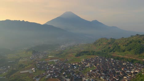 Township-and-misty-Mount-Sumbing-in-horizon,-aerial-view