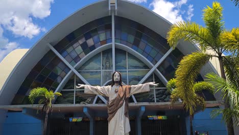 Exterior-of-St,-Joseph-Catholic-Church,-Colorful-Stained-Glass-and-Jesus-Christ-Statue-on-Sunny-Day