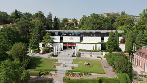 Establishing-aerial-of-the-Olympic-Museum-in-Lausanne,-Switzerland-on-a-sunny-summer-day