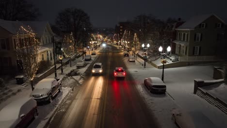 Town-street-covered-in-snow-and-decorated-with-Christmas-lights