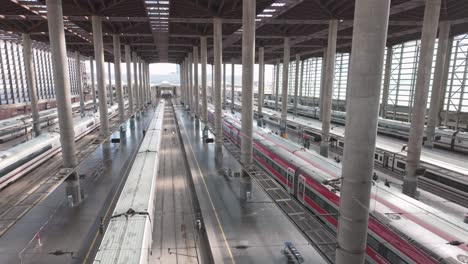 Panorámica-De-Izquierda-A-Derecha-Concurridos-Andenes-De-La-Estación-De-Tren-De-Atocha-En-Madrid-Durante-El-Día-Soleado-Trenes-De-Alta-Velocidad-En-La-Vía