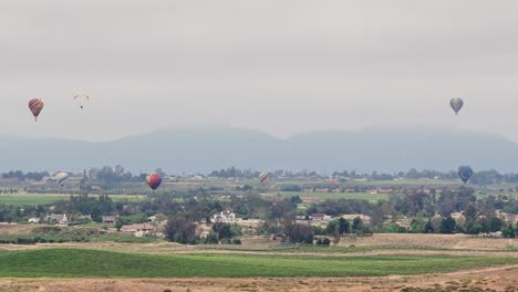 Temecula-Balloon-and-Wine-Festival-Six-Balloons-Drone-Movement-Sideways-to-Left-Paraglider-Enters-From-Left