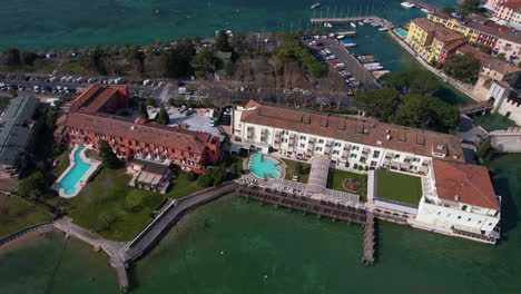 Aerial-View-of-Sirmione,-Italy,-Vintage-Buildings-on-Waterfront-of-Lake-Garda,-Drone-Shot
