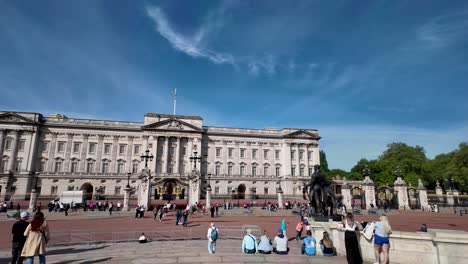 Buckingham-Palace-An-Einem-Sonnigen-Tag-Mit-Touristen-Und-Dem-Queen-Victoria-Memorial-Im-Vordergrund