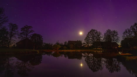 Nacht-Zeitraffer-Mit-Monduntergang-Und-Nordlichtern-über-Einem-Landhaus-Mit-Teich