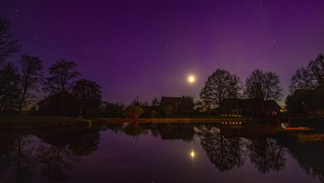 Timelapse-Nocturno-Con-Luna-Poniéndose-Y-Auroras-Boreales-Sobre-Casa-De-Campo-Con-Estanque