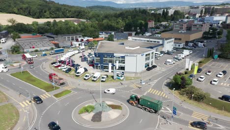 Jib-up-of-car-dealership-on-a-busy-industrial-site-with-traffic-driving-over-road-and-roundabout