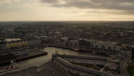 Panorámica-Aérea:-Hora-Dorada-De-La-Ciudad-De-Galway,-Muelles,-Coloridas-Casas-Irlandesas