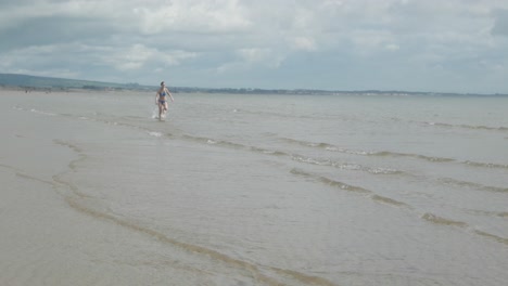 A-Lo-Largo-De-La-Costa-Aislada-Adolescente-Femenina-Corriendo-Sola,-Cámara-Lenta