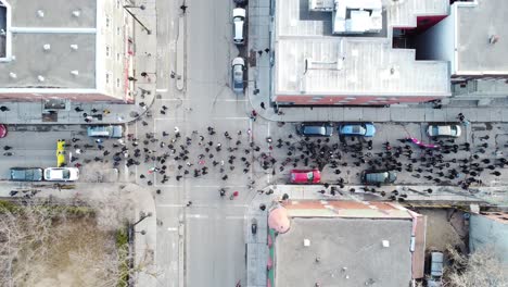 Large-crowd-gathers-for-a-peaceful-protest-in-downtown-Montréal,-highlighting-banners-and-flags,-on-a-sunny-day,-wide-shot