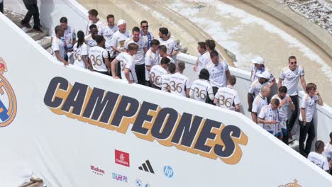 At-Cibeles-Square-in-Madrid,-Spain,-Real-Madrid-players-celebrate-their-36th-La-Liga-title-next-to-the-word-'Champions'-