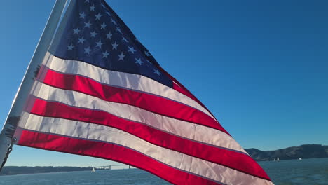 Amerikanische-Flagge-Weht-An-Einem-Sonnigen-Tag-Auf-Einer-Fähre,-Die-In-Der-Bucht-Von-San-Francisco-Segelt