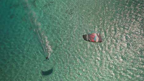 Drohnen-Luftaufnahme-Eines-Kiters-Beim-Surfen-Auf-Einem-Türkisfarbenen-Meer