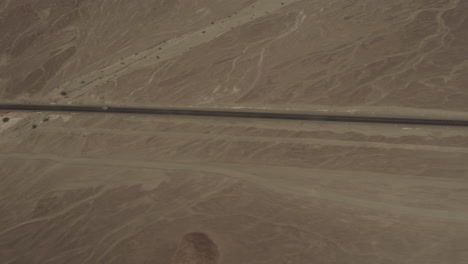 Aerial-of-road-over-Nasca-valley-desert-with-cars
