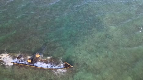 Drone-aerial-over-blue-water-and-the-historical-Mildura-shipwreck-with-waves-crashing-over-it