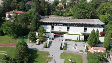 Beautiful-aerial-overview-of-the-Olympic-Museum-and-the-Olympic-park-in-Lausanne,-Switzerland-on-a-sunny,-summer-day