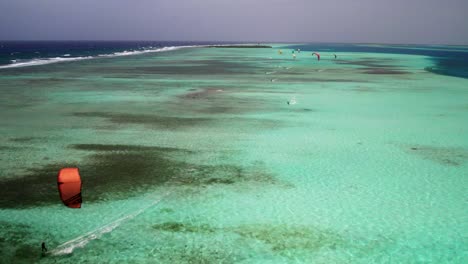 Kite-surfers-gliding-over-the-stunning-barrier-reef-in-los-roques,-aerial-view