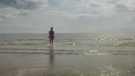 Niña-Corriendo,-Agua-Del-Océano,-Ubicación-En-La-Playa,-Sol-Dorado,-Cámara-Lenta