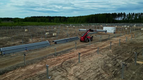 Luftdrohne-Fliegt-über-Solarfarm-Industriefeldern,-Lastwagen-Arbeiten-In-Ländlichen-Gebieten-Mit-Panorama-Bei-Tageslicht