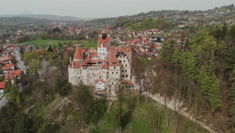 Aerial-establishing-shot-of-Dracula's-Vampire-Castle-in-Romania,-mountain-hill