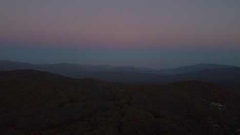 Aerial-of-forest-landscape-at-dusk-and-the-ocean-in-the-horizon