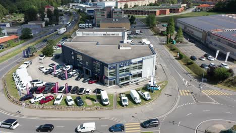 Aerial-view-of-Peugeot-car-dealership-adjacent-to-a-busy-road-adjacent-to-a-busy-industrial-site