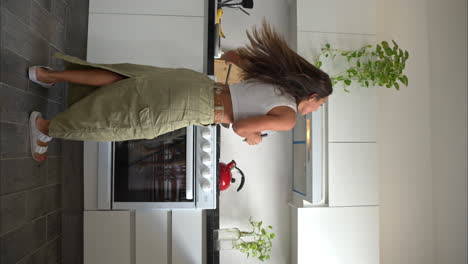 Vertical-slow-motion-of-a-mexican-latin-woman-dancing-while-she-is-cooking-enjoying-and-having-fun
