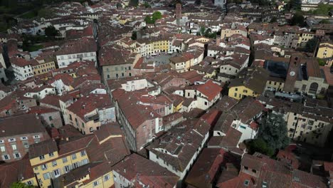 Lucca-Italy-busy-downtown-city-centre-as-sun-and-clouds-dance-over-city-aerial