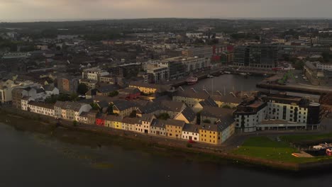 Cautivante-Descenso-Aéreo-Sobre-El-Largo-Paseo,-El-Centro-De-La-Ciudad-Y-El-Puerto-De-Galway.