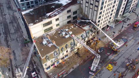 Aerial-of-Canadian-firefighter-handling-apartment-building-fire-accident-in-the-downtown-area-in-Ville-Marie,-Montreal,-Quebec,-Canada