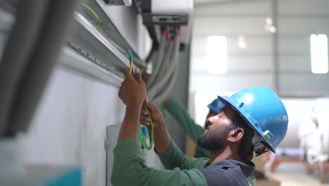 Electrical-Engineer-Putting-In-Wires-In-Conduit-At-Factory-In-Pakistan