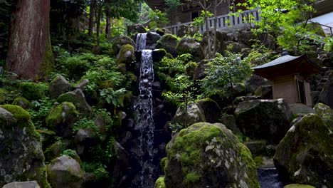 Hermosa-Cascada-Y-Pequeño-Río-En-El-Templo-Budista-En-Un-Frondoso-Bosque