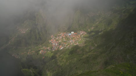 Secluded-mountain-village-in-green-valley-with-rolling-clouds,-Madeira