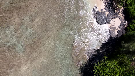 Cerrar-Panorámica-Aérea-Rápida-Sobre-Agua-Clara,-Rocas-Y-Palmeras.