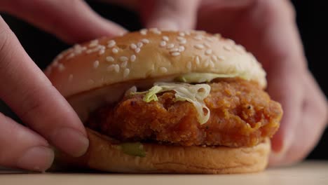 Person-Lay-Down-A-Crunchy-Fried-Chicken-Burger-On-The-Table