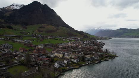 Aerial-View-of-Beckenried-Village-on-South-Bank-of-Lake-Lucerne,-Switzerland-on-Cloudy-Spring-Day,-Drone-Shot