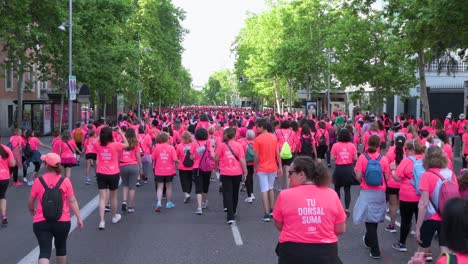 In-Madrid,-Spain,-thousands-of-participants-wearing-pink-shirts-take-to-the-streets-as-they-unite-for-the-Women's-Race,-promoting-awareness-of-metastatic-breast-cancer