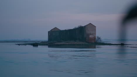 Verlassenes,-Rustikales-Gebäude-Auf-Einer-Kleinen-Insel-In-Der-Abenddämmerung,-Von-Einem-Boot-In-Burano,-Venedig-Gesehen