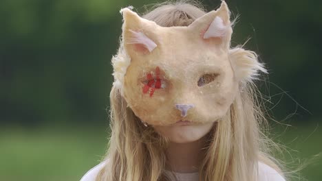 Porträt-Eines-Mädchens-Mit-Katzenmaske,-Das-Mitten-Im-Grünen-Steht