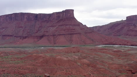 Aerial-view,-drone-fly-backward-shot-bottom-up,-majestic-buttes-of-monument-of-red-rocks-canyon-in-valley-of-Utah