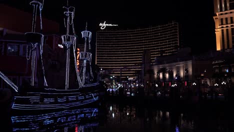 Las-Vegas-USA-Strip-at-Night,-Treasure-Island-Boat-and-Wynn-Casino-Hotel-in-Lights