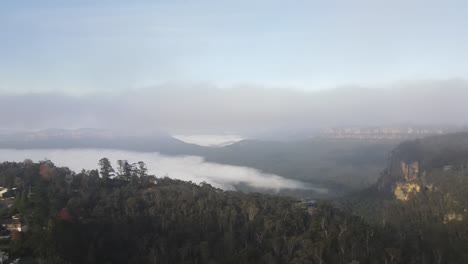 Drone-aerial-moving-backwards-from-the-blue-mountains-to-reveal-the-town-of-Katoomba-on-a-cloudy-day