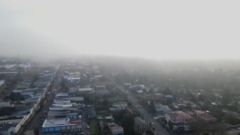 Drone-aerial-flying-through-clouds-over-a-town-in-the-blue-mountains