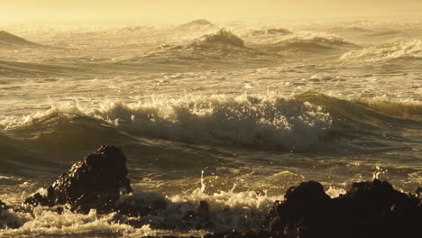 Rough-Sea-Waves-Crashing-On-Rocky-Shoreline-During-Golden-Afternoon---Close-Up-Static-Shot