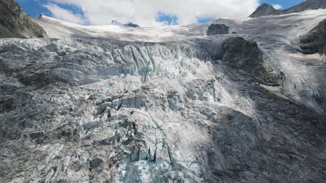 Der-Moiry-Gletscher-In-Der-Schweiz-An-Einem-Klaren-Tag-Mit-Schroffen-Eisformationen-Und-Schneebedeckten-Gipfeln,-Luftaufnahme