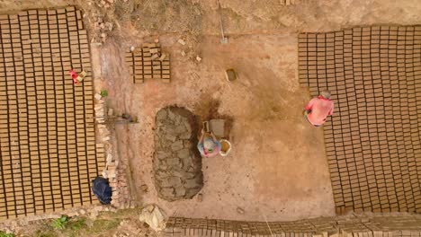 Traditional-man-made-brick-industry-worker-making-bricks-with-clay-and-wooden-moulding-and-arranging-them-in-a-row-to-dry-up