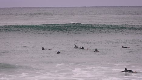 Surfers-paddling-out-through-waves-at-Duranbah-Beach,-Southern-Gold-Coast