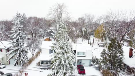Neighborhood-of-houses-covered-in-snow,-snowstorm-suburb-homes,-snowfall-flyover
