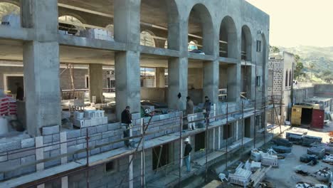 Construction-workers-stand-on-scaffolding